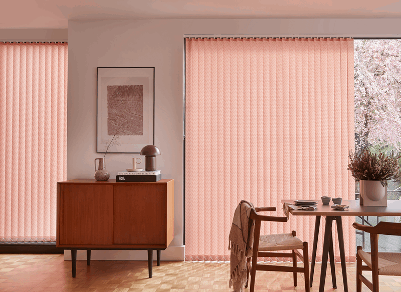 Dining room with pink vertical blinds, wooden furniture, and a table.