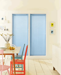 Dining room with blue window blinds and colorful chairs.