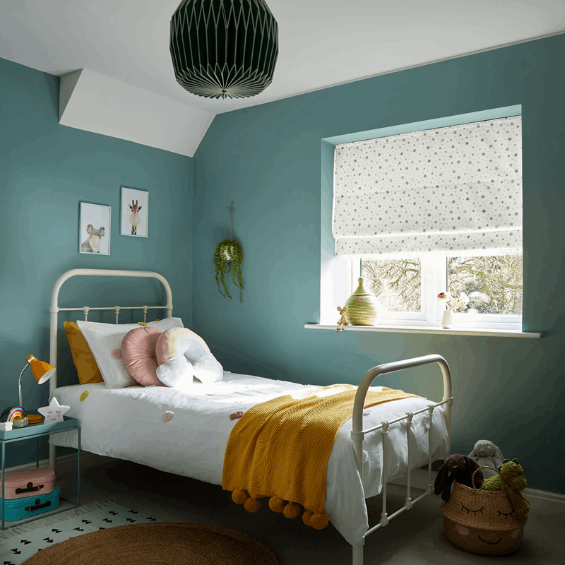 Children's bedroom with teal walls, white bed, and yellow blanket.